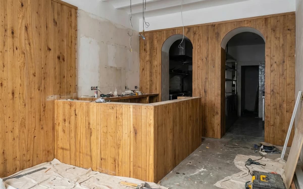 Antes: Barra de mármol con taburetes y estantería de madera de olivo