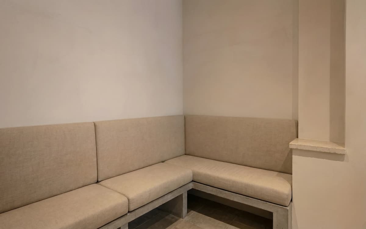 Antes: Rincón íntimo con banqueta tapizada y mesas de roble