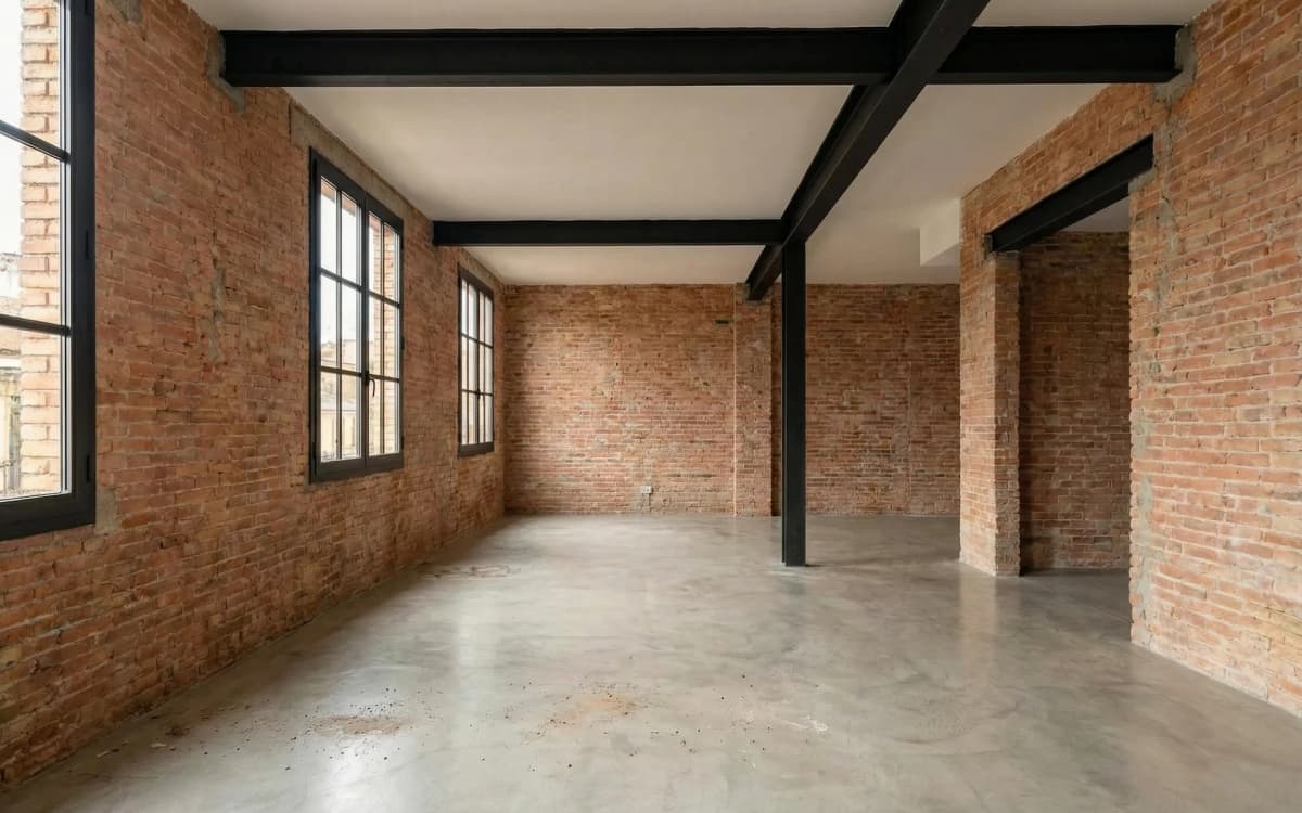Antes: Salón del loft industrial con ladrillo visto y vigas de acero